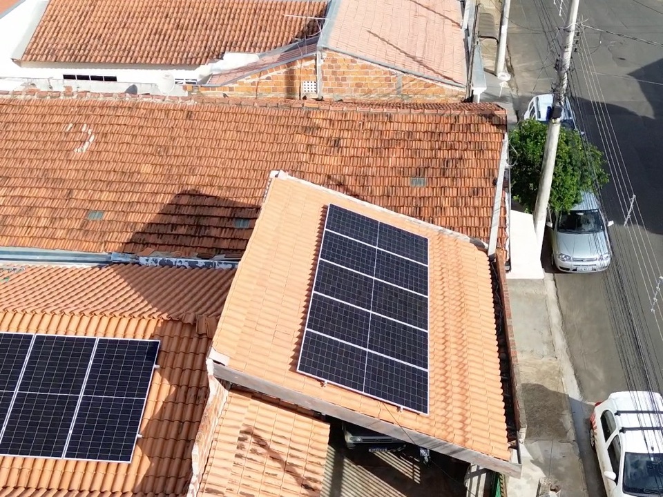 Placas solares no telhado inclinado de telha cerâmica de uma casa, vistas de drone